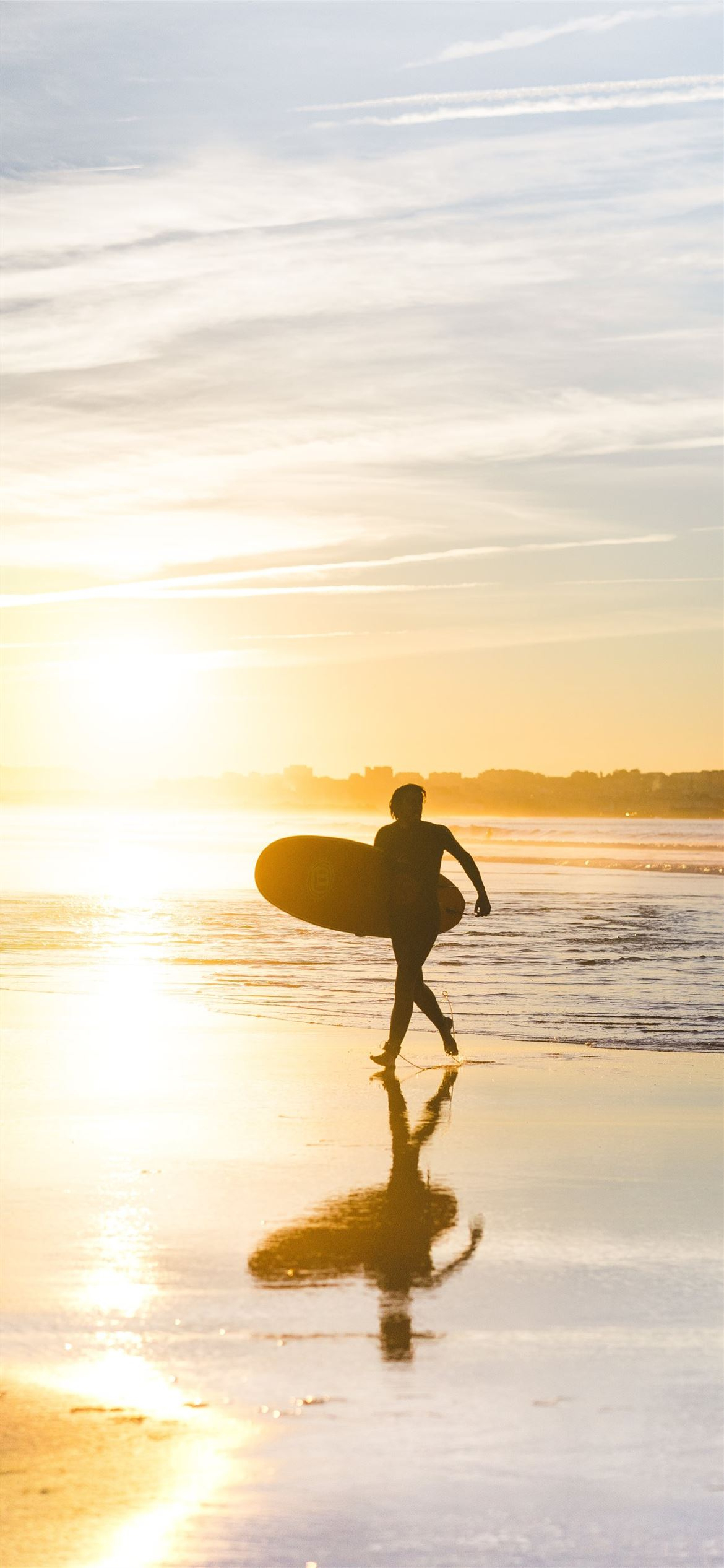 1170x2532 man holding surfboard at seaside iPhone 12 Wallpapers Free Download